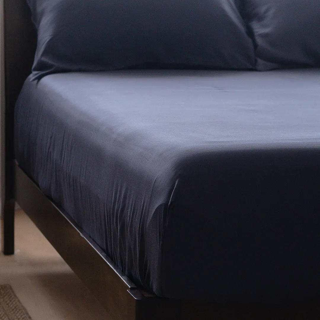 Navy fitted sheet on bed corner